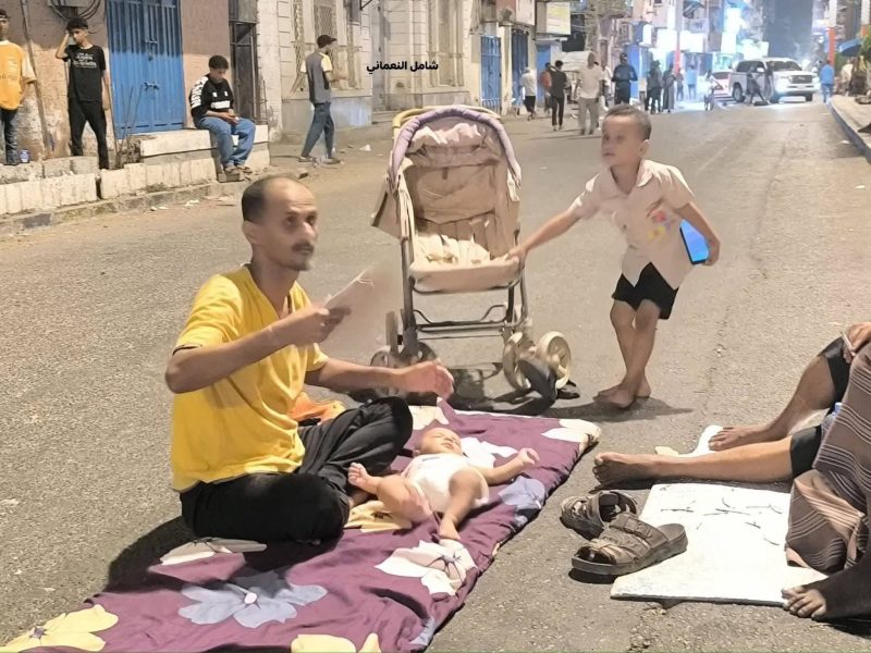 عدن.. صورة مؤلمة لأب عدني يفترش الشارع مع طفلة الرضيع بحثا عن الهواء